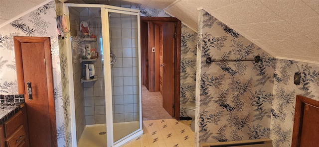 bathroom featuring vaulted ceiling, toilet, and wallpapered walls