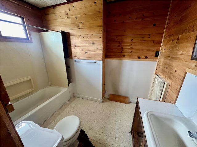 full bath with toilet, wood walls, shower / bath combination, and a sink