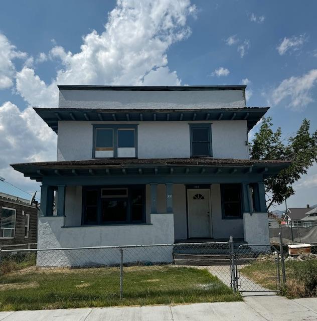 view of front of house featuring a fenced front yard, covered porch, and stucco siding