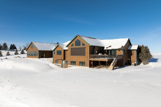 snow covered property with covered porch and stairway