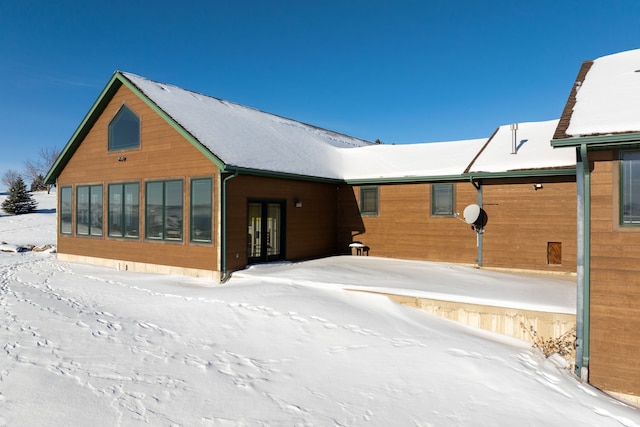 view of snow covered back of property