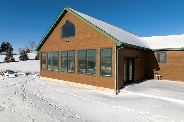 view of snow covered back of property