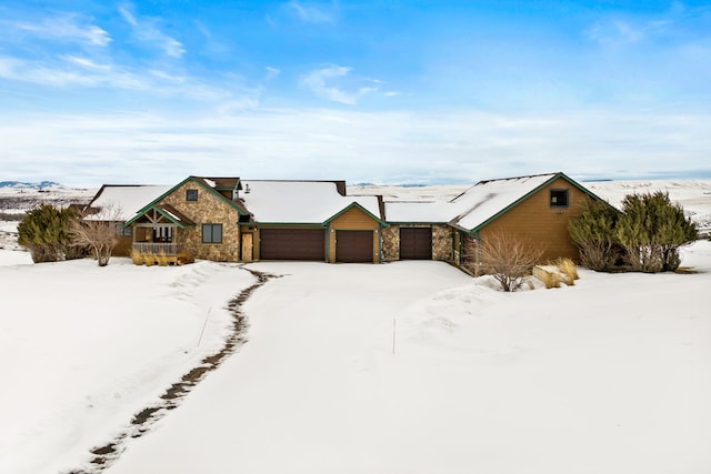 view of front of property featuring stone siding and a detached garage