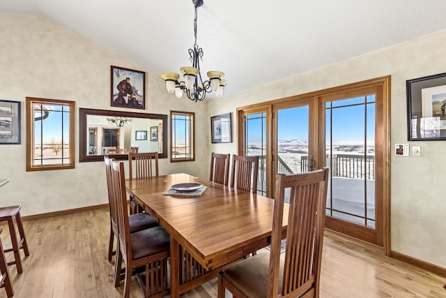 dining room with an inviting chandelier, baseboards, vaulted ceiling, and light wood finished floors