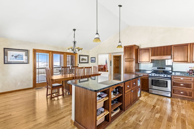 kitchen with a kitchen island, brown cabinets, stainless steel gas stove, open shelves, and decorative light fixtures