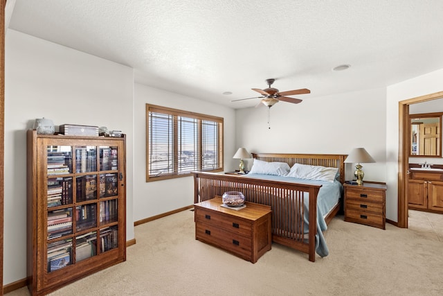 bedroom with baseboards, a ceiling fan, light colored carpet, a textured ceiling, and a sink