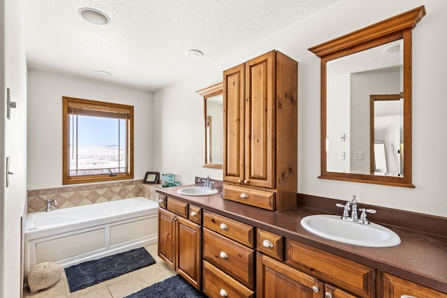 bathroom featuring tile patterned floors, a sink, a textured ceiling, and a bath