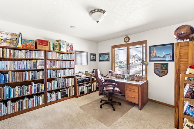 home office featuring light carpet, baseboards, and a textured ceiling