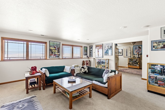 living area with baseboards, a textured ceiling, and light colored carpet