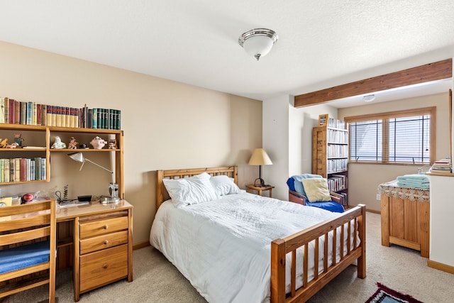 bedroom with light colored carpet, a textured ceiling, and baseboards