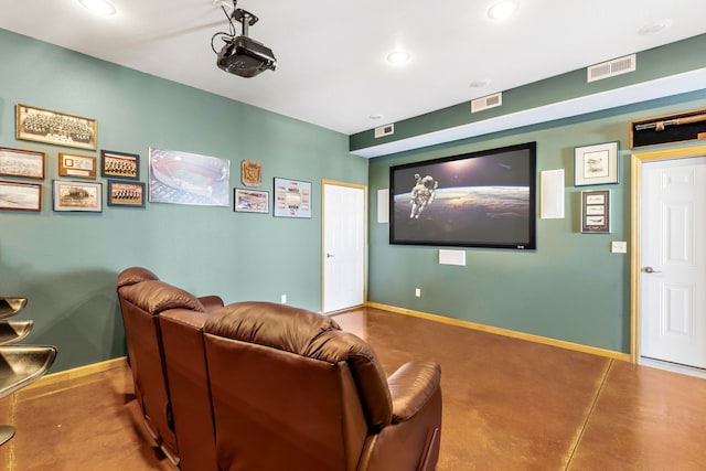 home theater with concrete flooring, visible vents, and baseboards