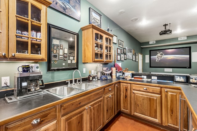 kitchen featuring dark countertops, a sink, visible vents, and brown cabinets