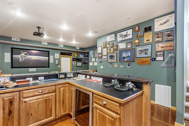 interior space featuring dark countertops, beverage cooler, visible vents, and brown cabinetry