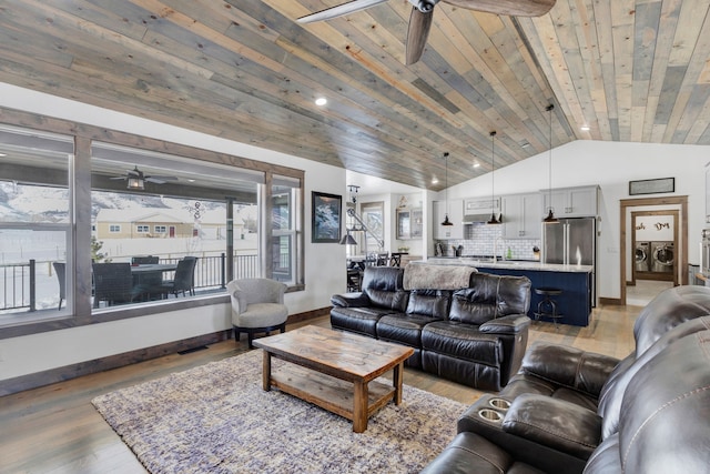 living room with ceiling fan, wooden ceiling, wood finished floors, washer and dryer, and vaulted ceiling