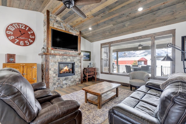 living area featuring a ceiling fan, lofted ceiling, wood ceiling, wood finished floors, and a fireplace