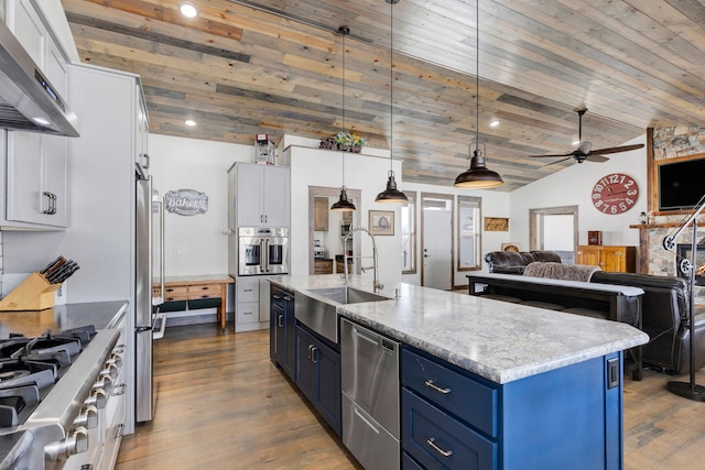 kitchen with blue cabinetry, ventilation hood, decorative light fixtures, and white cabinets