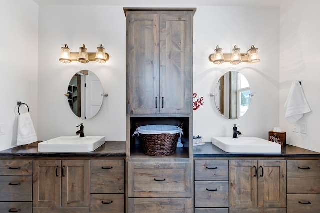 full bathroom with a sink and double vanity