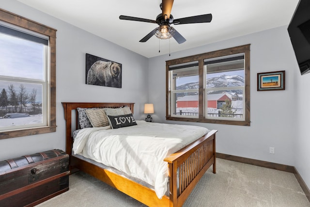 bedroom with a ceiling fan, light carpet, and baseboards