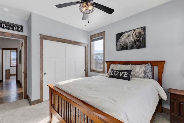 bedroom with a ceiling fan, a closet, carpet flooring, and baseboards