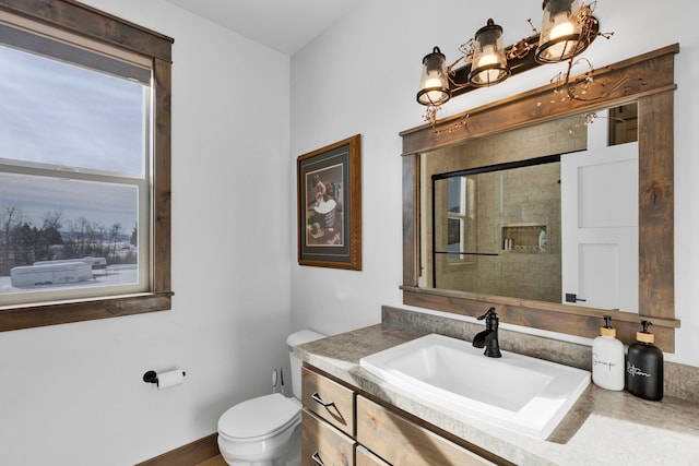 bathroom with toilet, baseboards, and vanity