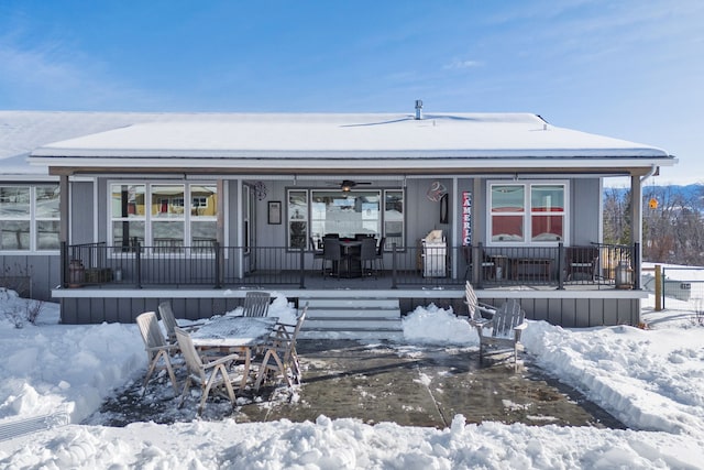 snow covered back of property with covered porch