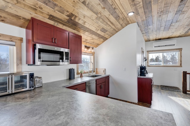 kitchen with a sink, wood ceiling, dark brown cabinets, stainless steel microwave, and a wall mounted air conditioner