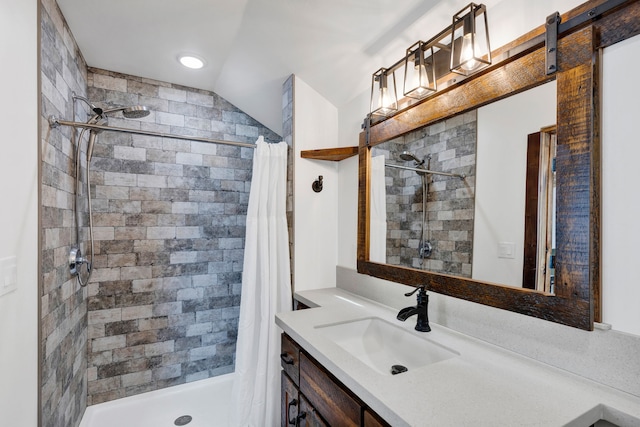 bathroom with vaulted ceiling, vanity, and a shower stall