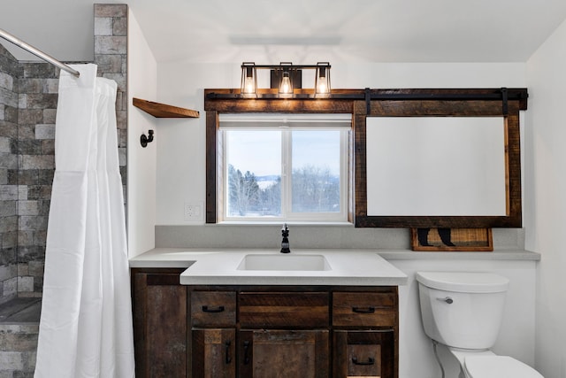 full bathroom with a tile shower, vanity, and toilet