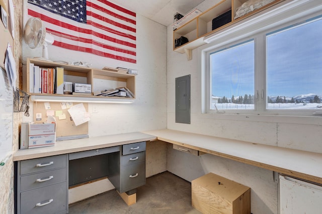 office area featuring concrete flooring, electric panel, and built in study area