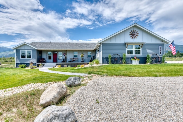 ranch-style house with a porch, a front lawn, and board and batten siding