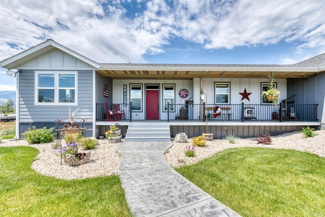 single story home featuring a porch, board and batten siding, and a front lawn