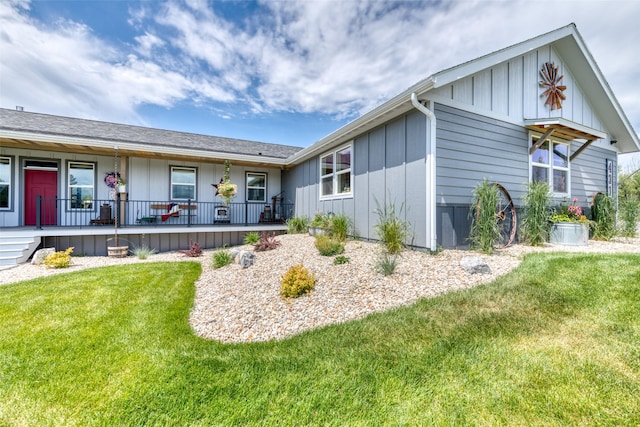 ranch-style home featuring covered porch, board and batten siding, and a front yard