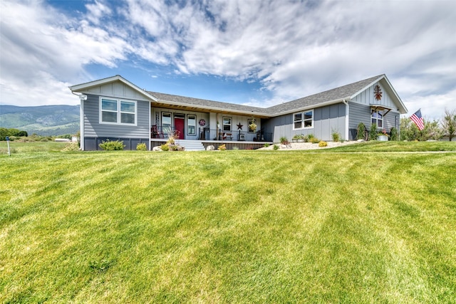 ranch-style house with covered porch, a front lawn, and board and batten siding