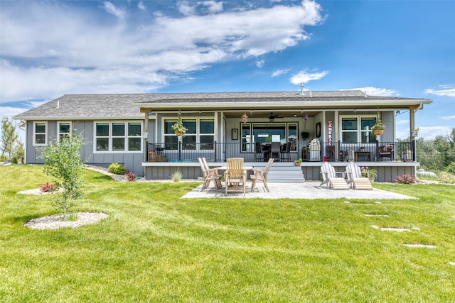 rear view of property with ceiling fan, a patio, a lawn, and board and batten siding