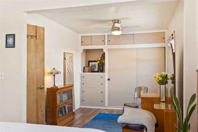 living area with a ceiling fan and wood finished floors