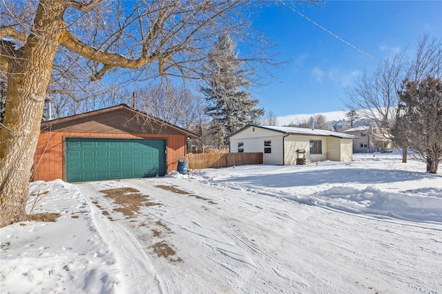 exterior space with a detached garage and fence