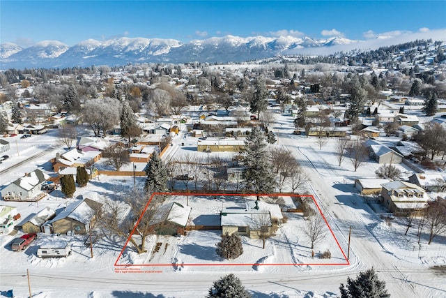 snowy aerial view with a residential view and a mountain view