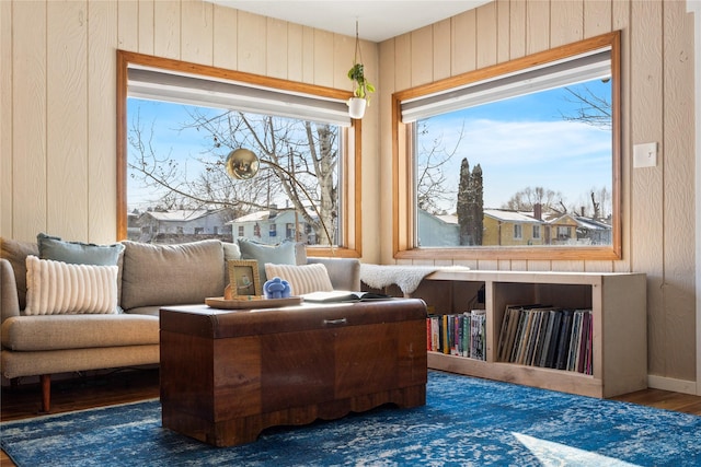 sitting room featuring wood walls and dark wood-type flooring