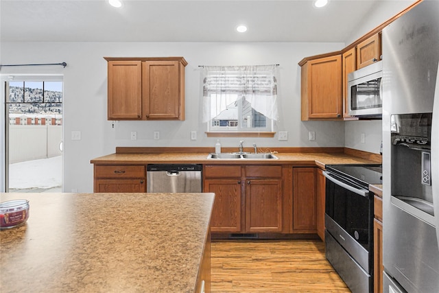 kitchen with a sink, stainless steel appliances, light countertops, and recessed lighting