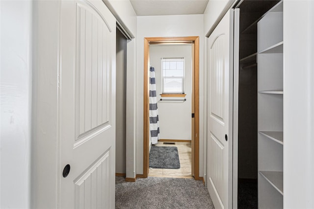 hall featuring carpet and baseboards