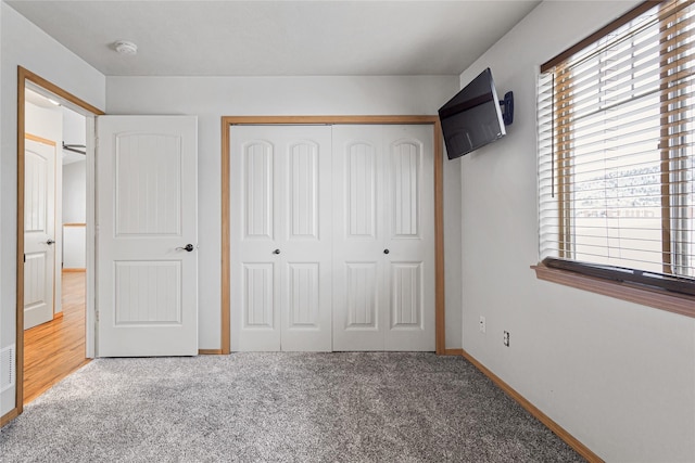 unfurnished bedroom with carpet, baseboards, and a closet