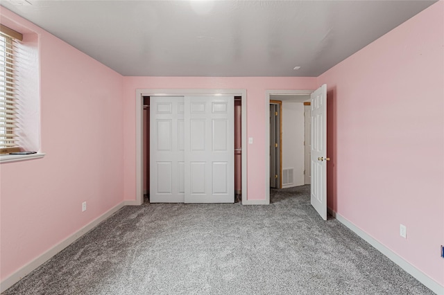 unfurnished bedroom featuring a closet, carpet, visible vents, and baseboards