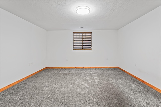 unfurnished room featuring a textured ceiling, baseboards, and carpet flooring