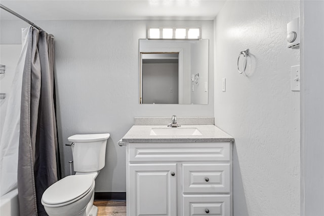 full bath with shower / tub combo, a textured wall, vanity, and toilet