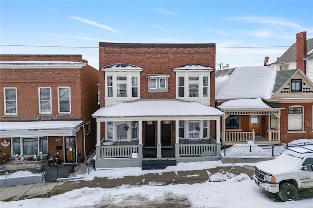 view of front of home featuring covered porch and brick siding