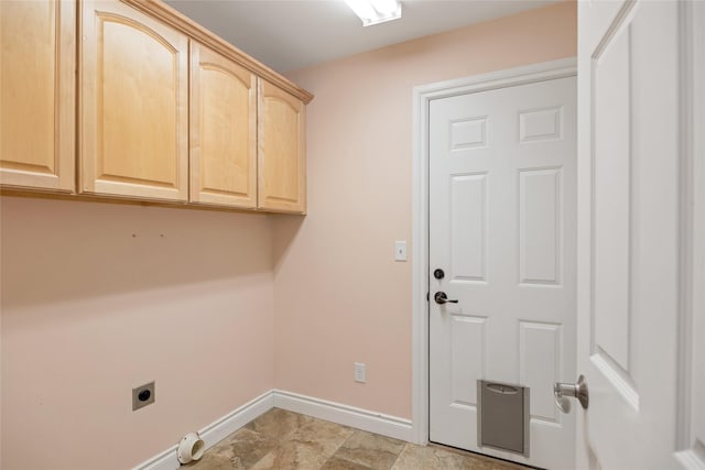 clothes washing area featuring cabinet space, electric dryer hookup, and baseboards