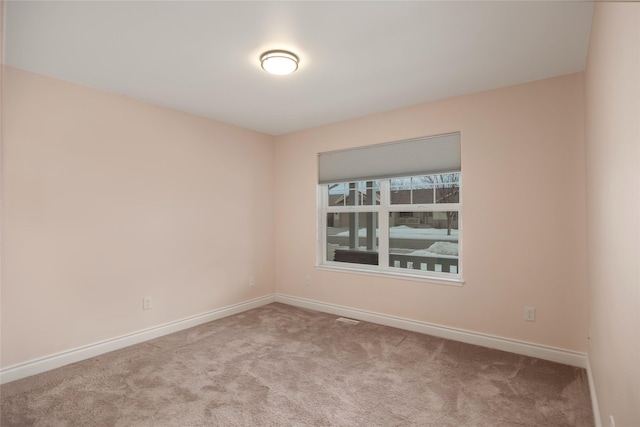 unfurnished room with light carpet and baseboards