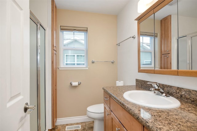 bathroom featuring toilet, a wealth of natural light, vanity, and visible vents