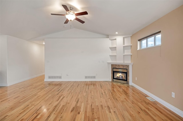 unfurnished living room with light wood-type flooring, a multi sided fireplace, visible vents, and baseboards