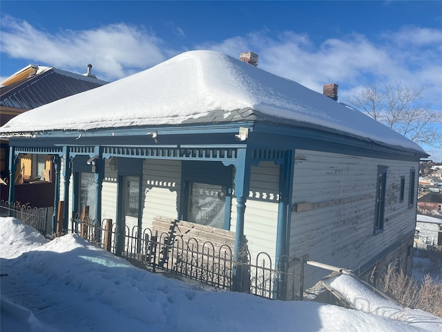 view of front of home featuring a fenced front yard and a chimney